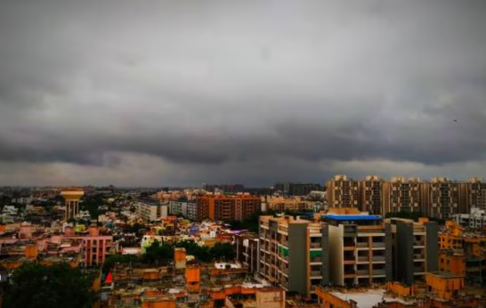 અમદાવાદમાં ચોમાસાની ઋતુ દરમિયાન આકાશમાં છવાયેલા વાદળો અને ભીના રસ્તાઓનું દ્રશ્ય